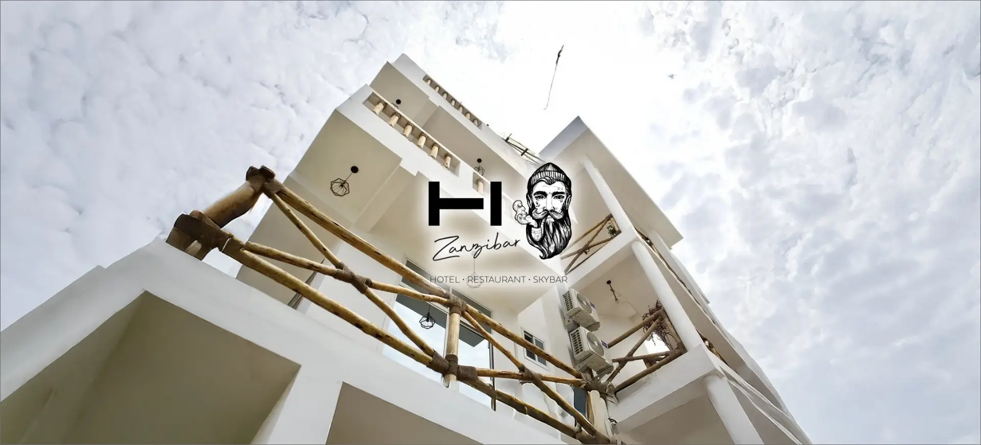 Die Fassade des "Zanzibar" Hotels mit angrenzendem Restaurant und Skybar, das eine atemberaubende Aussicht bietet. Die Architektur ist modern, elegant und einladend, mit einer Terrasse, die den Blick über die Stadt freigibt.