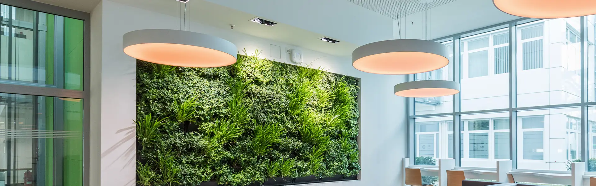 Das Bild zeigt eine moderne Gebäudeautomation, die verschiedene technische Systeme eines Gebäudes effizient überwacht und steuert. Auf einem Display sind Echtzeit-Daten zum Energieverbrauch sowie zur Funktion von Heizungs-, Lüftungs- und Klimaanlagen sichtbar. In der Umgebung sind digitale Steuerpulte und Monitoranzeigen zu sehen, die die intelligente Steuerung und das Energiemanagement in einem Bürogebäude darstellen. Die Technologie dient der Optimierung des Energieverbrauchs und der Sicherstellung von Komfort und Nachhaltigkeit im Gebäude.